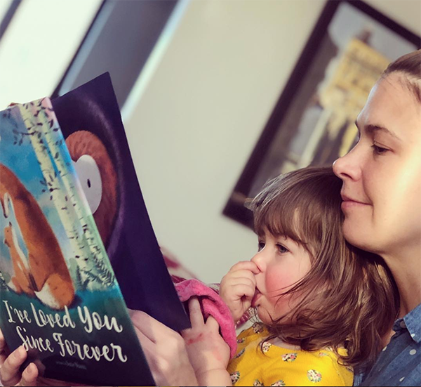 Sutton and her daughter reading book